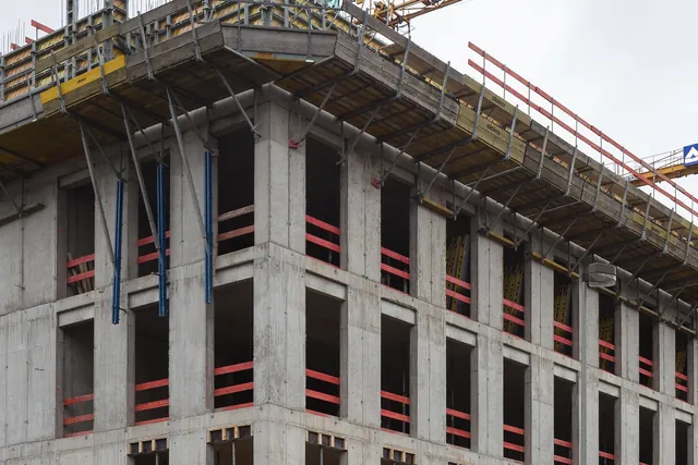Rangka beton gedung kantor yang sedang dibangun dengan kren menara